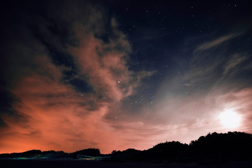 Bright full moon glowing against a dark blue night sky filled with stars